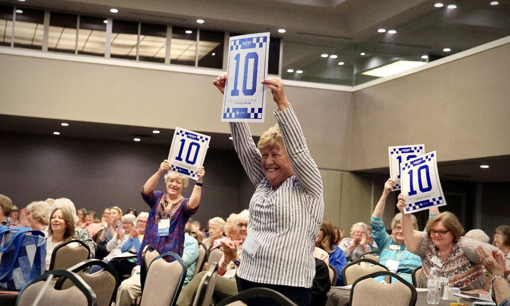 Several KEHA State Board members hold up Perfect 10 signs in celebration of the choir’s performance.